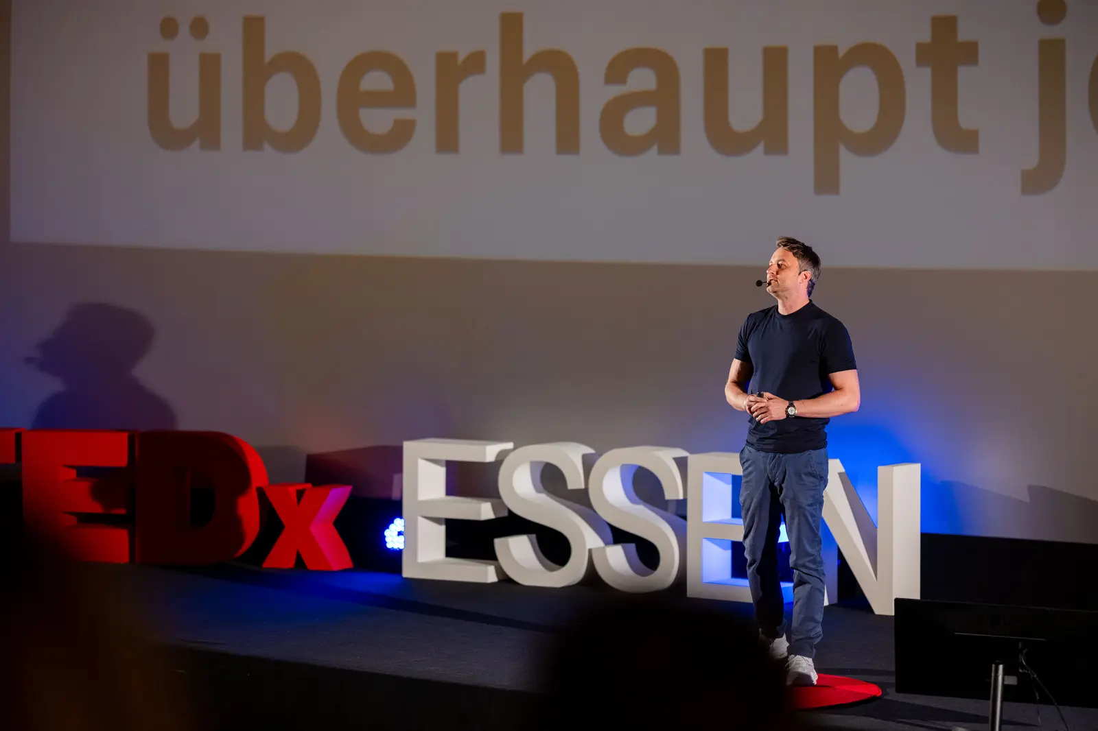 Speaker standing in front of the TEDx ESSEN letters