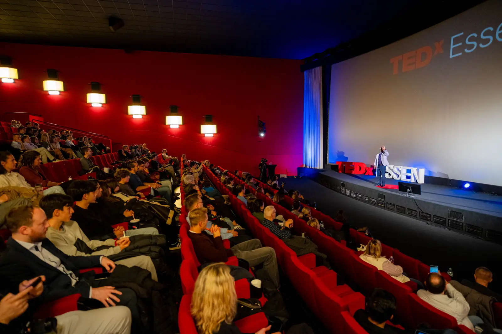 Full hall seen from the back rows towards the stage