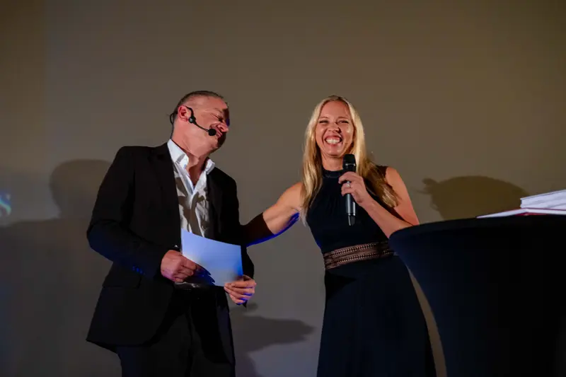 The two hosts presenting on stage